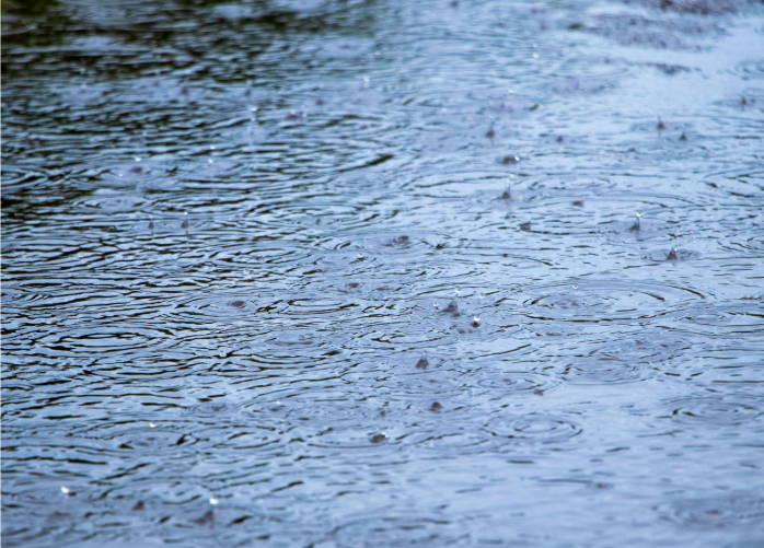 Heavy raindrops hitting a large pool of water
